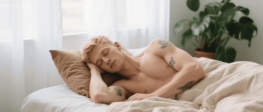 Shirtless tattooed man resting on a bed
