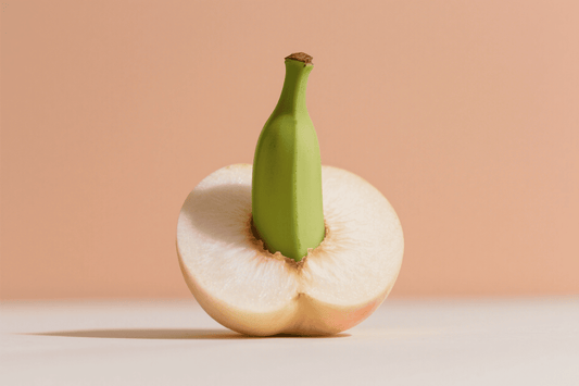Green bottle inserted into a halved white melon on a peach background