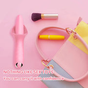 Compact pink tongue vibrator beside a small handbag